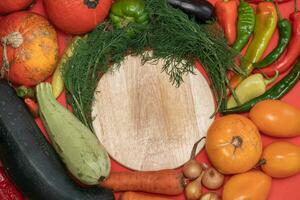 Vegetables are laid out around empty place. Empty space for text. Vegetables on a wooden board. photo