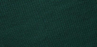Texture of smooth knitted dark green sweater with pattern. Top view, close-up. Handmade knitting wool or cotton fabric texture. Background of Large Ribs knit pattern with knitting needles or crochet. photo