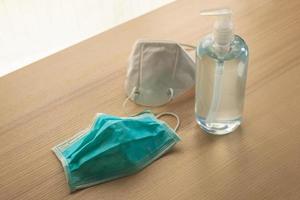 Medical face mask with alcohol sanitizer gel hand wash on wood table for covid-19 Coronavirus prevention concept photo