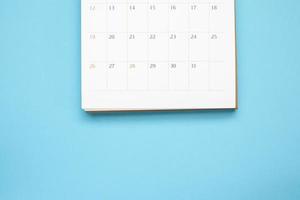 calendar page close up on blue background business planning appointment meeting concept photo