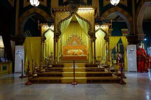 Istana Maimun, Medan North Sumatera, Indonesia - October 23, 2021, Orange bed with pillows and decorated with golden curtains photo