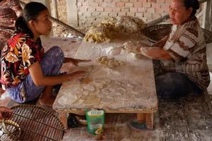 ogan ilir, indonesia - 27 de octubre de 2021, dos mujeres trabajan y hablan entre sí hacen comida tradicional foto