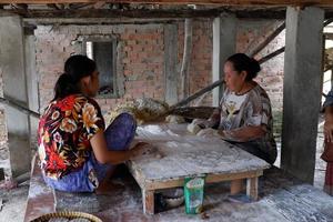 ogan ilir, indonesia - 27 de octubre de 2021, dos mujeres trabajan y hablan entre sí hacen comida tradicional foto