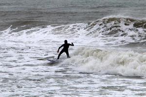 surfeando en olas altas en el mar mediterráneo en el norte de israel. foto