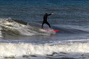 Surfing on high waves on the Mediterranean Sea in northern Israel. photo