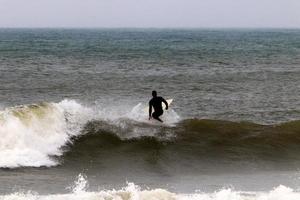 Surfing on high waves on the Mediterranean Sea in northern Israel. photo