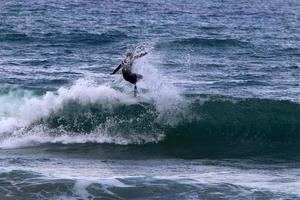 surfeando en olas altas en el mar mediterráneo en el norte de israel. foto