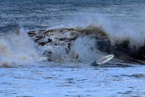 surfeando en olas altas en el mar mediterráneo en el norte de israel. foto