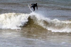 Surfing on high waves on the Mediterranean Sea in northern Israel. photo