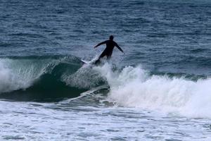 Surfing on high waves on the Mediterranean Sea in northern Israel. photo