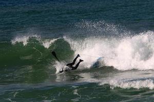 surfeando en olas altas en el mar mediterráneo en el norte de israel. foto
