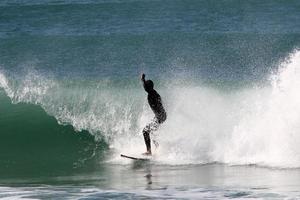 surfeando en olas altas en el mar mediterráneo en el norte de israel. foto