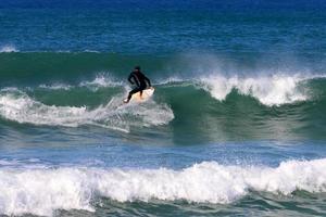 Surfing on high waves on the Mediterranean Sea in northern Israel. photo