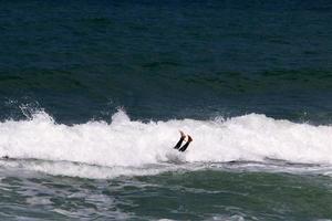 Surfing on high waves on the Mediterranean Sea in northern Israel. photo