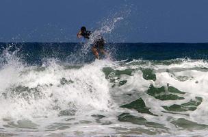 surfeando en olas altas en el mar mediterráneo en el norte de israel. foto