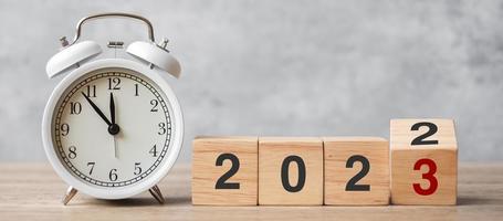 Happy New Year with vintage alarm clock and flipping 2022 change to 2023 block. Christmas, New Start, Resolution, countdown, Goals, Plan, Action and Motivation Concept photo
