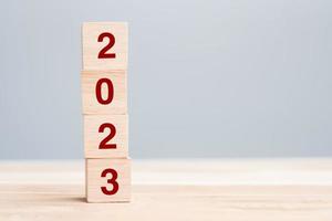 wooden cube block with 2023 text on table background. Resolution, plan, review, goal, start and New Year holiday concepts photo