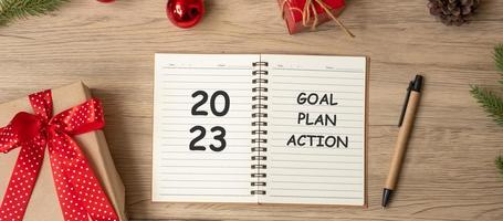 2023 Goal Plan Action with notebook, Christmas gift and pen on wood table. Xmas, Happy New Year, Resolution, To do list, start and Strategy concept photo
