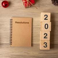 2023 año nuevo con cuaderno, regalo de navidad y bolígrafo sobre mesa de madera. navidad, feliz año nuevo, objetivos, resolución, lista de tareas, inicio, estrategia y concepto de plan foto