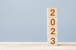 wooden cube block with 2023 text on table background. Resolution, plan, review, goal, start and New Year holiday concepts photo