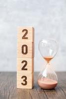 2023 block with hourglass on table. Resolution, time, plan, goal, motivation, reboot, countdown  and New Year holiday concepts photo