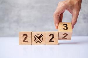 hand flip 2022 to 2023 block with dartboard sign. Business Goal, Target, Resolution, strategy, plan, Action motivation, change, thinking, countdown and New Year start concepts photo