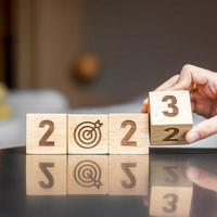 hand flip 2022 to 2023 block with dartboard sign. Business Goal, Target, Resolution, strategy, plan, Action motivation, change, thinking, countdown and New Year start concepts photo