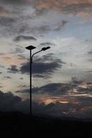 silhouette public street lighting pole with LED lights with an amazing sunset color background photo