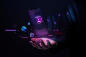 conceptos de tecnología metaverse y blockchain. persona con experiencias del mundo virtual del metaverso a través de un teléfono inteligente. tono futurista. mano levitando teléfono móvil foto