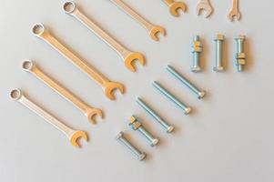 New wrenches on grey background, top view with space for text. professional plumber tools with fixing bolts. photo