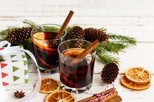 vino caliente de navidad con canela, cardamomo y anís sobre fondo de madera blanca, tarjeta de felicitación de año nuevo foto