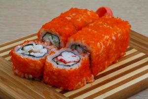 California roll on wooden board and wooden background photo