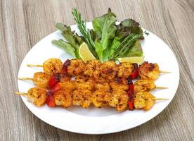 Prawn skewer on the plate and white background photo