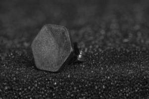 close-up of matt hexagon earring on glittery silver background photo