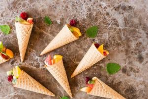 waffle cones with fruit on a marble table. flat lay. photo