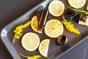 essential aromatic oil with citrus fruits on a black background. the concept of beauty and skin care of the face and body. photo