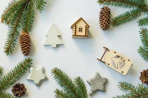 white festive background with spruce branches, cones, silver stars and wooden toys. top view. photo