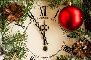 an antique clock on New Year's eve or Christmas night with a countdown to midnight in festive decoration.