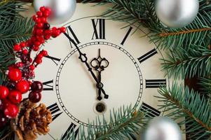 Christmas clock with silver balls, New Year's branch with red berries and cones. the concept of meeting the new year and Christmas. photo