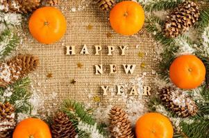 New Year's background with tangerines laid out on burlap, spruce branches and cones. rustic Russian style. photo