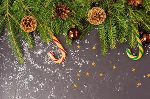 black snow-covered New Year's background with spruce branches, toys, confetti. top view. space for text. photo