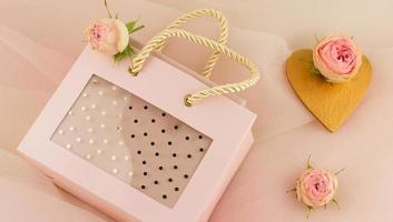 Valentine's Day. a nice gift for the holiday in a beautiful package on a pastel background with pink roses. the concept of a romantic gift. photo