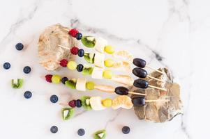 canapés de fruta jugosa sobre piedras y mesa de mármol. composición de verano. alimentación saludable. foto