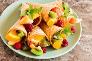 fruit dessert. waffle cones with fruit on a plate. close angle. photo