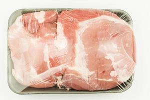 A large piece of raw pork meat packed hermetically on a black plastic tray. top view. white background. A collection of packaging template layouts. photo