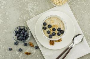 healthy breakfast with oatmeal and fresh organic berries and blueberries. Flat design on linen napkin. top view. photo