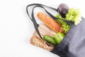 top view of a dark cloth bag filled with organic products . the concept of the right choice of products, zero waste when buying without plastic. photo