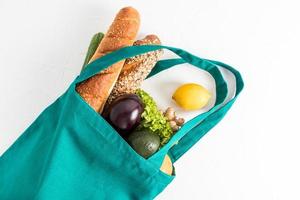 top view of a bag made of canvas eco-friendly material filled with vegetables, yu fruits, vegan. the concept of buying the right food. photo