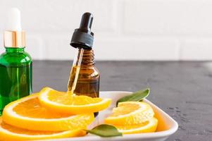 pipeta con aceite de naranja cosmético en la burbuja naranja. cosmética natural. vitamina C. foto