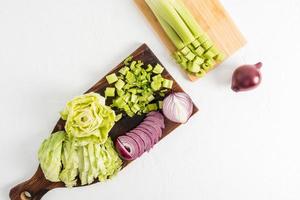 top view of two wooden kitchen boards with vegetables cut on them for salad. the concept of healthy eating, vitamins. white background. photo